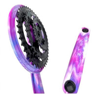 Juego de bielas y platos TONYBIKESGDL con diseño marmolado en tonos violeta, rosa y azul y platos negros resistentes.