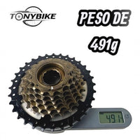 Cassette de 7 velocidades TONYBIKESGDL con piñones negro y bronce sobre báscula digital marcando 491 gramos