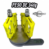 Pedales de plataforma TONYBIKESGDL de nylon amarillo con pines metálicos sobre báscula digital mostrando 341 gramos
