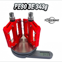 Pedales de plataforma TONYBIKESGDL de nylon rojo con pines de agarre sobre una báscula digital marcando 343 gramos