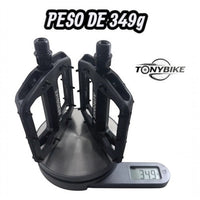 Pedales de plataforma TONYBIKESGDL negros para BMX y MTB con pines de tracción sobre una báscula digital de 349g.