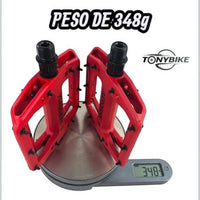 Pedales de plataforma rojos TONYBIKESGDL Aerobmx con pines de agarre sobre una báscula digital marcando 348 gramos.