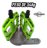 Pedales de plataforma TONYBIKESGDL Aerobmx color verde vibrante con pines de tracción sobre báscula digital de 348g