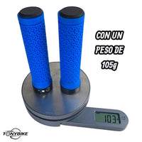 Puños TONYBIKESGDL azules para bicicleta con textura antideslizante y patrón geométrico sobre una báscula digital.