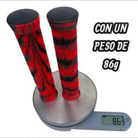 Puños para bicicleta TONYBIKESGDL rojos y negros con textura ergonómica sobre una báscula digital marcando 86 gramos