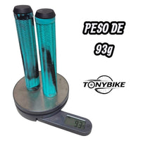 Puños para bicicleta TONYBIKESGDL en color turquesa y negro con patrón ergonómico en zigzag sobre una báscula digital.