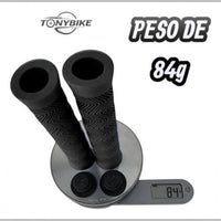 Puños para bicicleta TONYBIKESGDL negros con textura zigzag antideslizante sobre báscula digital marcando 84 gramos
